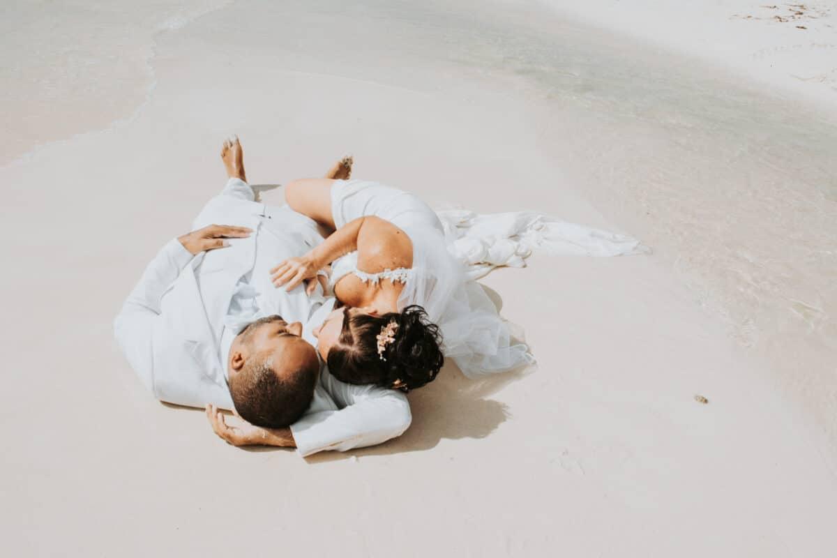Bride laying over groom on the beach during Trash the Dress session – Mexico wedding photography