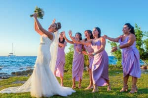 Bridesmaids reaching for the bouquet during a fun beach wedding ceremony in Cozumel – destination wedding photography