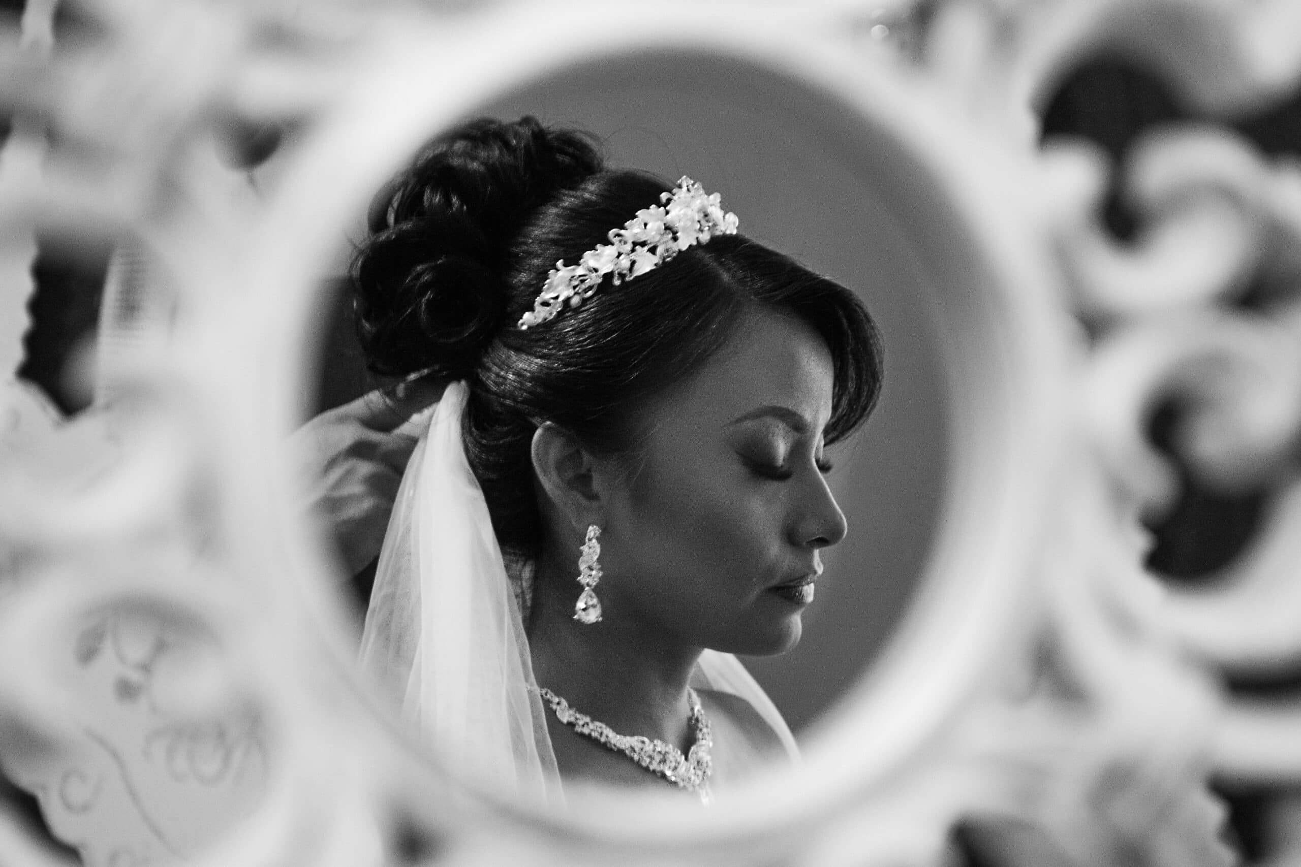 Artistic black and white photo of a bride reflected in a mirror before her destination wedding in the Riviera Maya