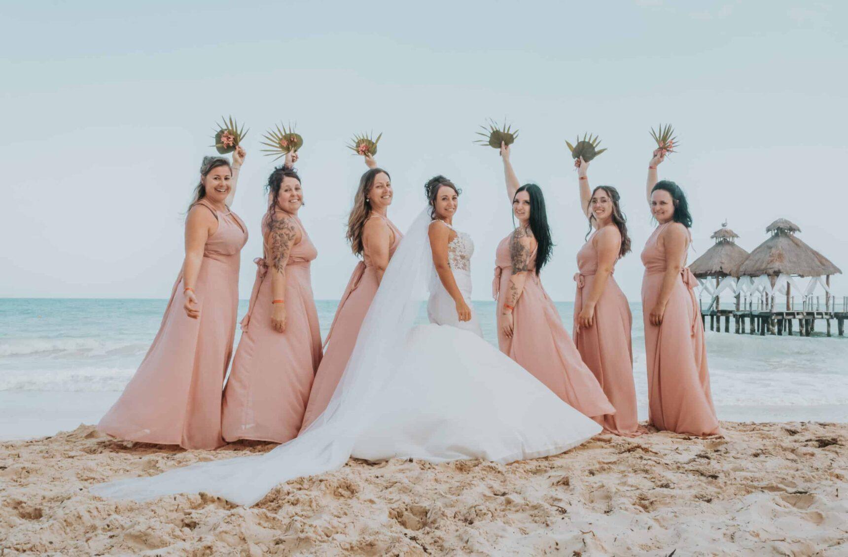 Bride and groom laughing with their wedding party during a fun candid moment in Cancun, captured by affordable wedding photographers