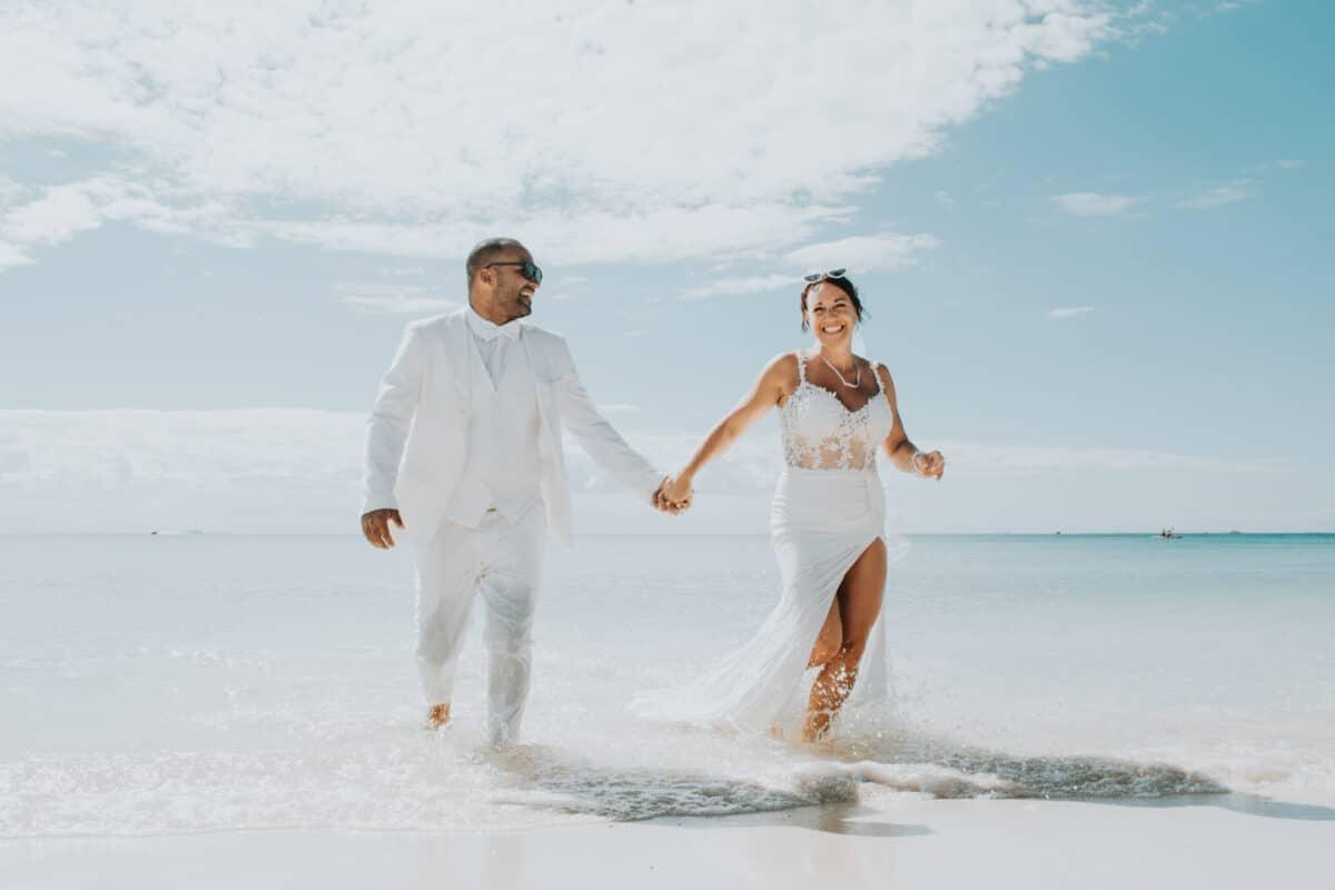 Bride and groom walking hand in hand into the sea – Trash the Dress beach session in Punta Esmeralda