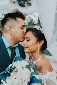 Bride and groom almost kissing with their excited bridal party behind them, captured by Lili and Lime Photography – a moment made for wedding photos framed.