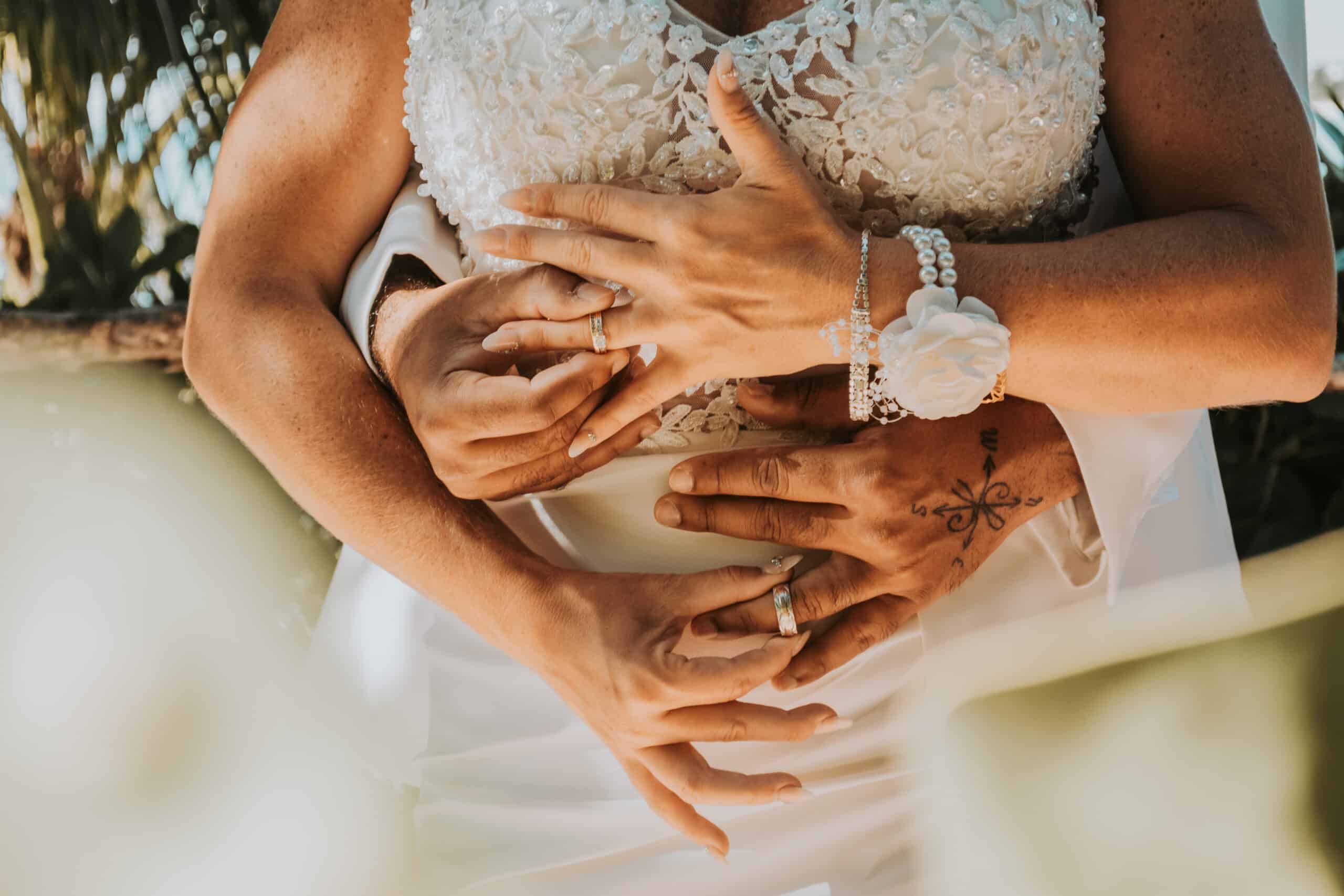 Close-up of newlyweds’ hands showing their wedding rings, captured by a professional wedding studio offering affordable wedding photography services.