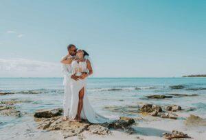 Newlywed couple embracing in the ocean during their trash the dress photo shoot in Costa Mujeres, Cancun
